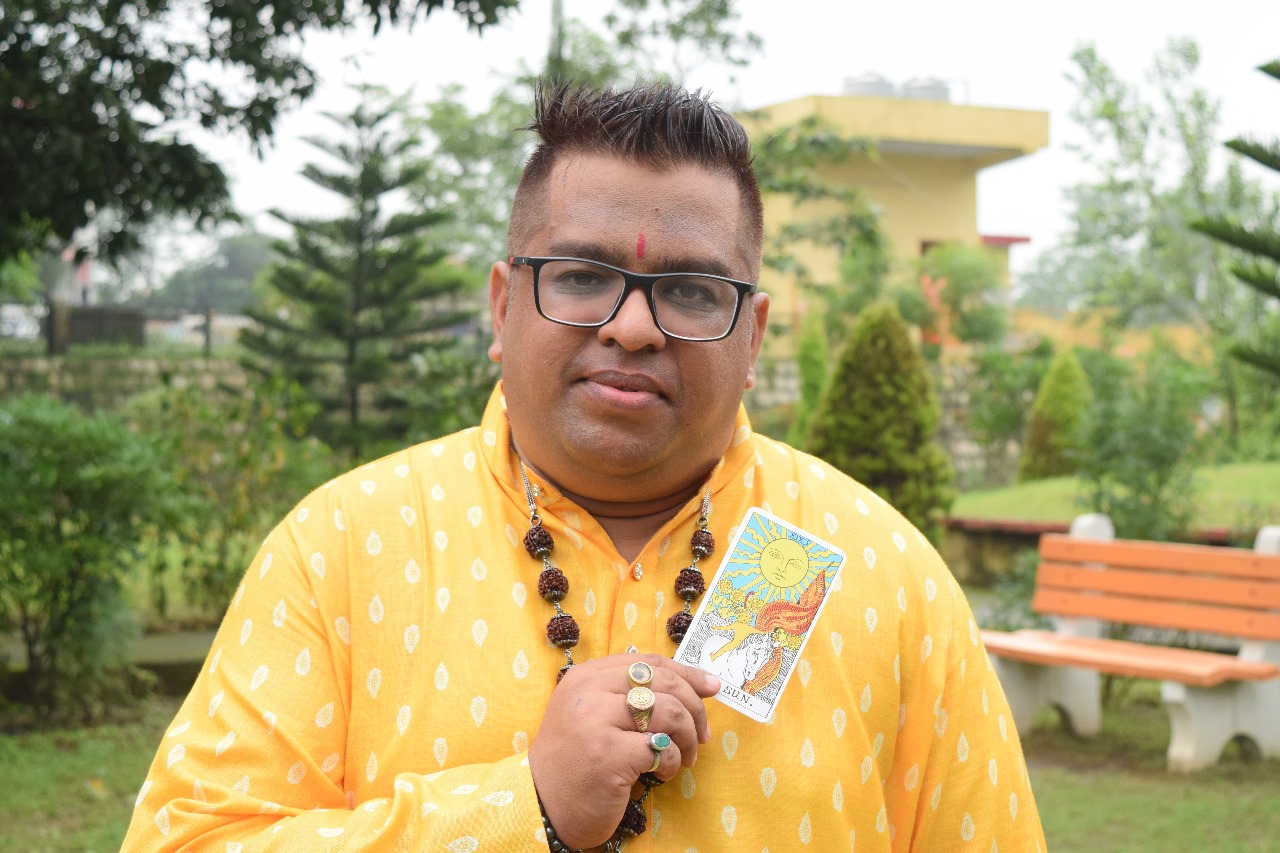 Dr. Vivek G Goel holding a Tarot card
